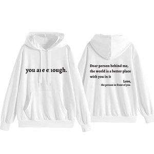 Détail du sweat blanc montrant l'imprimé You Are Enough et le texte inspirant au dos