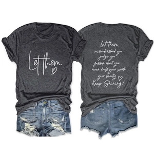 Dettaglio della t-shirt grigio scuro con stampa Let Them e pantaloncini in denim strappati