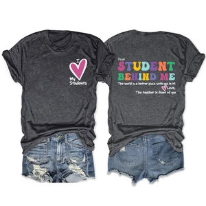 Détail du texte imprimé et du motif cœur sur un t-shirt gris pour enseignant à col rond
