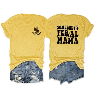 Flat lay of mustard yellow t-shirt with Feral Mama print and ripped denim shorts
