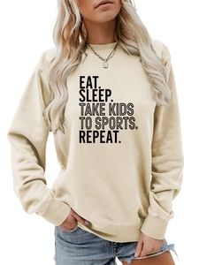 Détail du slogan Eat Sleep Take Kids To Sports sur un sweat beige à col rond