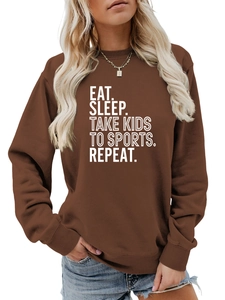 Détail du slogan blanc imprimé sur un sweat-shirt marron foncé à manches longues