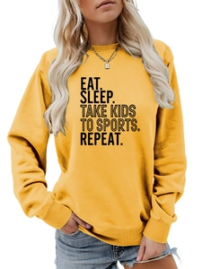 Détail de l'imprimé noir EAT SLEEP TAKE KIDS sur un sweat-shirt jaune à col rond