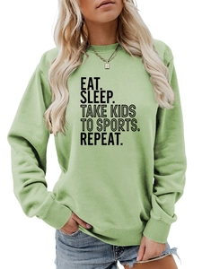 Détail de l'imprimé EAT SLEEP TAKE KIDS TO SPORTS sur un sweat-shirt vert sauge