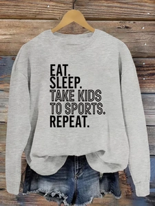 Détail du texte imprimé Eat Sleep Take Kids to Sports sur un sweat-shirt gris