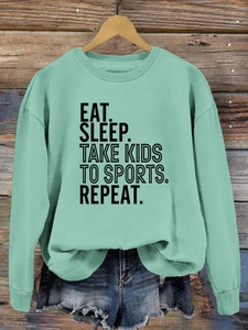 Détail du slogan Eat Sleep Take Kids To Sports sur le sweat-shirt vert menthe