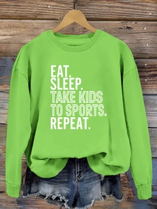 Détail de l'imprimé Eat Sleep Take Kids sur un sweat-shirt à col rond vert vif