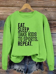 Détail du slogan Eat Sleep Take Kids To Sports imprimé sur un sweat-shirt vert néon