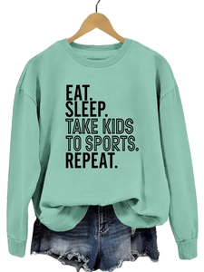 Détail de l'imprimé Eat Sleep Take Kids To Sports sur le sweat-shirt vert menthe