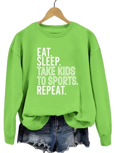 Détail du sweat vert avec texte Eat Sleep Take Kids et short en jean effiloché