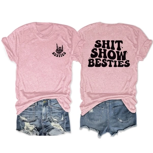 Detail view of pink cotton t-shirts featuring SHIT SHOW BESTIES prints and denim shorts