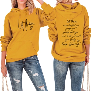 Detail of yellow hoodie featuring motivational black lettering and front kangaroo pocket