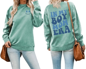 Front and back view of mint green sweatshirt featuring blue smile and Boy Mom Era print