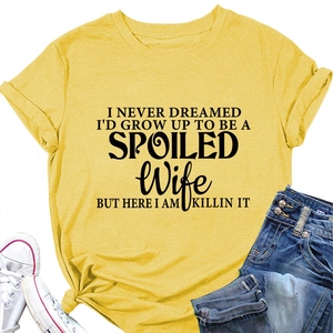 Detail of yellow round neck T-shirt with black Spoiled Wife slogan and knotted hem style