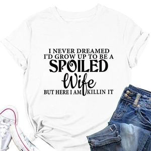 Detail view of cotton t-shirt featuring black spoiled wife slogan on a flat lay display