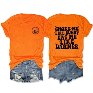 Close-up of orange cotton t-shirt with Choke Me Like Bundy print and denim shorts