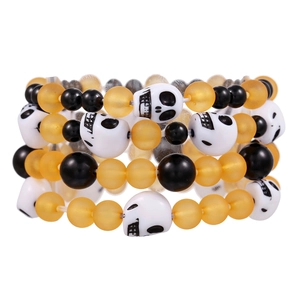 Dettaglio del set di braccialetti con perline arancioni, nere e teschi bianchi
