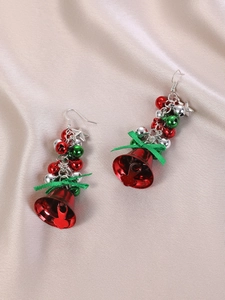 Detailed macro view of Christmas bells earrings with red bells and green ribbon bows