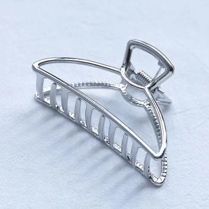Minimalist silver half-moon metal hair claw clip with a polished finish and hollow design