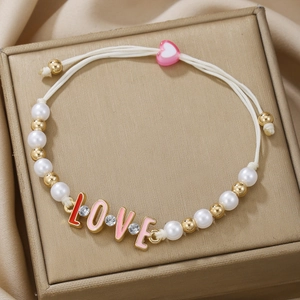 Handmade woven bracelet with white pearls, gold beads, and a pink heart sliding clasp with LOVE charm