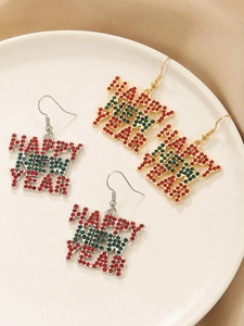 Detail of red and green rhinestone Happy New Year drop earrings in gold and silver finish