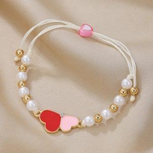 Handmade beaded heart bracelet with white pearls and pink enamel charms on champagne silk