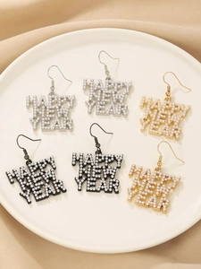 Macro detail of Happy New Year rhinestone earrings in gold, silver, and black finishes
