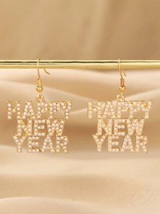 Detail of Happy New Year gold earrings with pearl inlays on a satin background