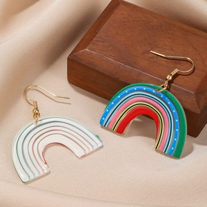 Boucles d'oreilles arc-en-ciel en résine acrylique avec crochets dorés sur satin chaud