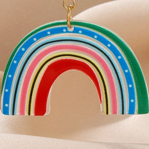 Détail macro du pendentif arc-en-ciel en acrylique avec rayures colorées et anneau