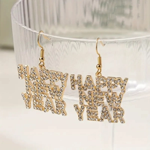 Golden Happy New Year rhinestone drop earrings hanging on a stylish glass rim