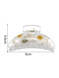 Detail view of 9cm clear crescent hair claw with embedded white daisy dried flowers