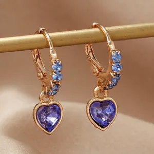 Boucles d'oreilles cœur dorées avec pierres bleues et diamants sur support métal