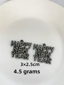 Macro view of rhinestone encrusted Happy New Year alloy charms with 3x2.5cm dimensions