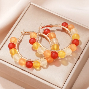 Colorful beaded C-shape hoop earrings with gold metal and matte finish beads on satin