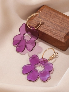 Detailed close-up of purple acrylic flower petals on golden metal hoop earrings
