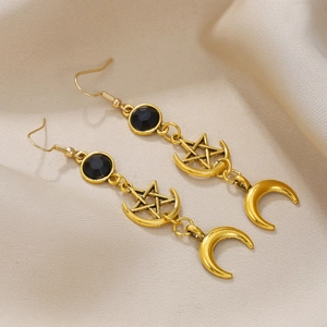 Golden star and crescent moon drop earrings with black gemstones on silk fabric
