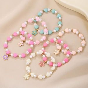 Set of five colorful children beaded bracelets with heart pearls and flower pendants