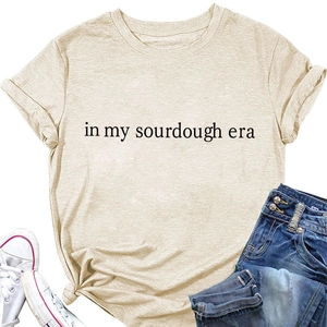 Detail of apricot T-shirt with 'in my sourdough era' print and hem knot styling