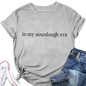 Detail of grey T-shirt featuring In My Sourdough Era text and stylish knotted waist design