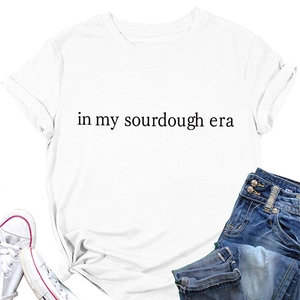 Flat lay of a white cotton t-shirt featuring black in my sourdough era printed text