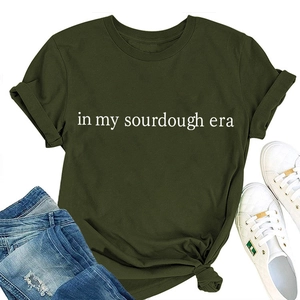 Flat lay of an olive green sourdough era cotton t-shirt styled with denim and sneakers