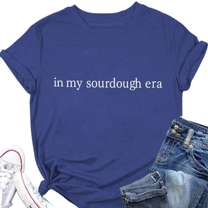 Flat lay of navy blue In My Sourdough Era t-shirt with denim shorts and white sneakers