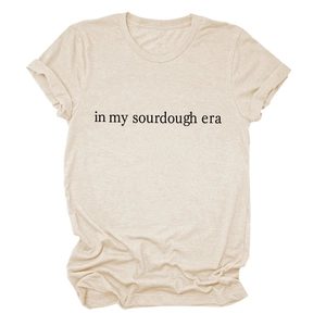 Detail showing In My Sourdough Era text print on beige cotton crewneck t-shirt