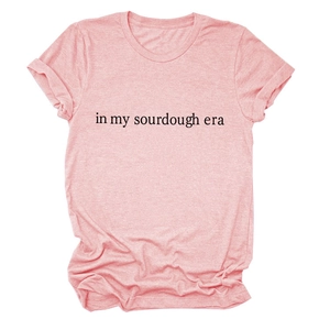 Detailed flat lay of pink cotton T-shirt featuring In My Sourdough Era text print