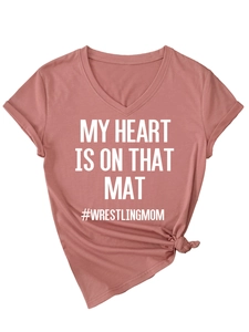 Detail of V-neck wrestling mom T-shirt with knotted hem and printed slogan on pink fabric