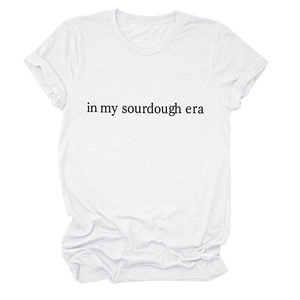 Close-up of the black 'in my sourdough era' text on a white cotton crewneck t-shirt