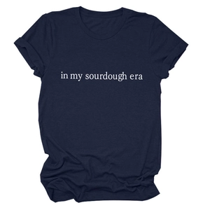 Detailed flat lay of navy blue cotton t-shirt with in my sourdough era white text