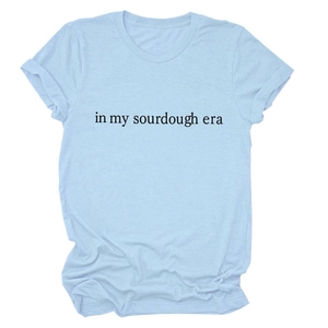 Detail of light blue cotton T-shirt featuring 'in my sourdough era' black serif text