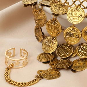 Golden boho body chain jewelry with hollow star ring and embossed coins on satin backdrop